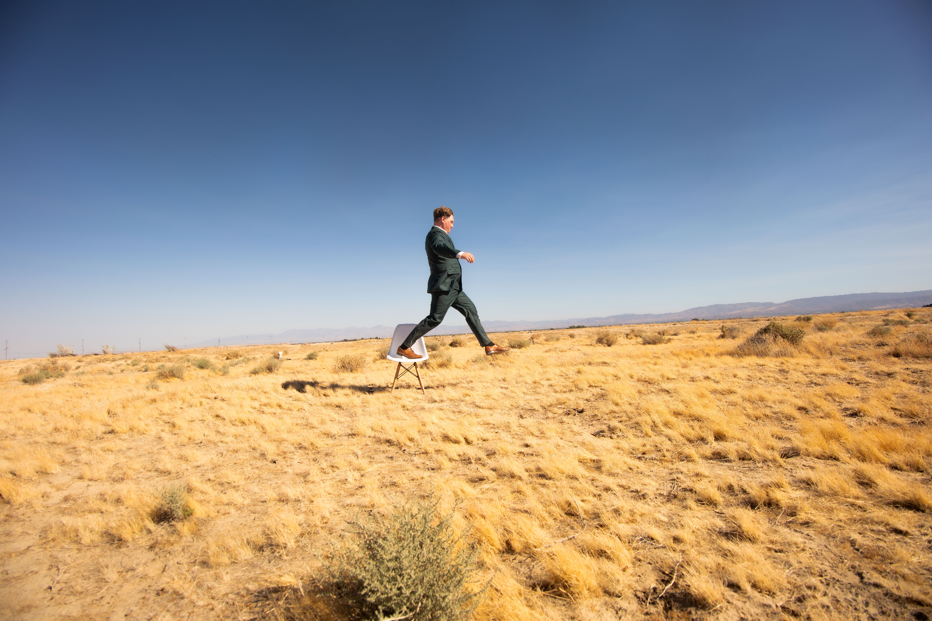 Scott Syme walking through the desert in a suit