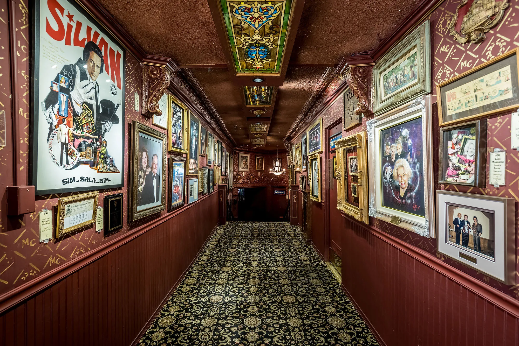 The Magic Castle hallway lined with portraits and memorabilia of legendary magicians